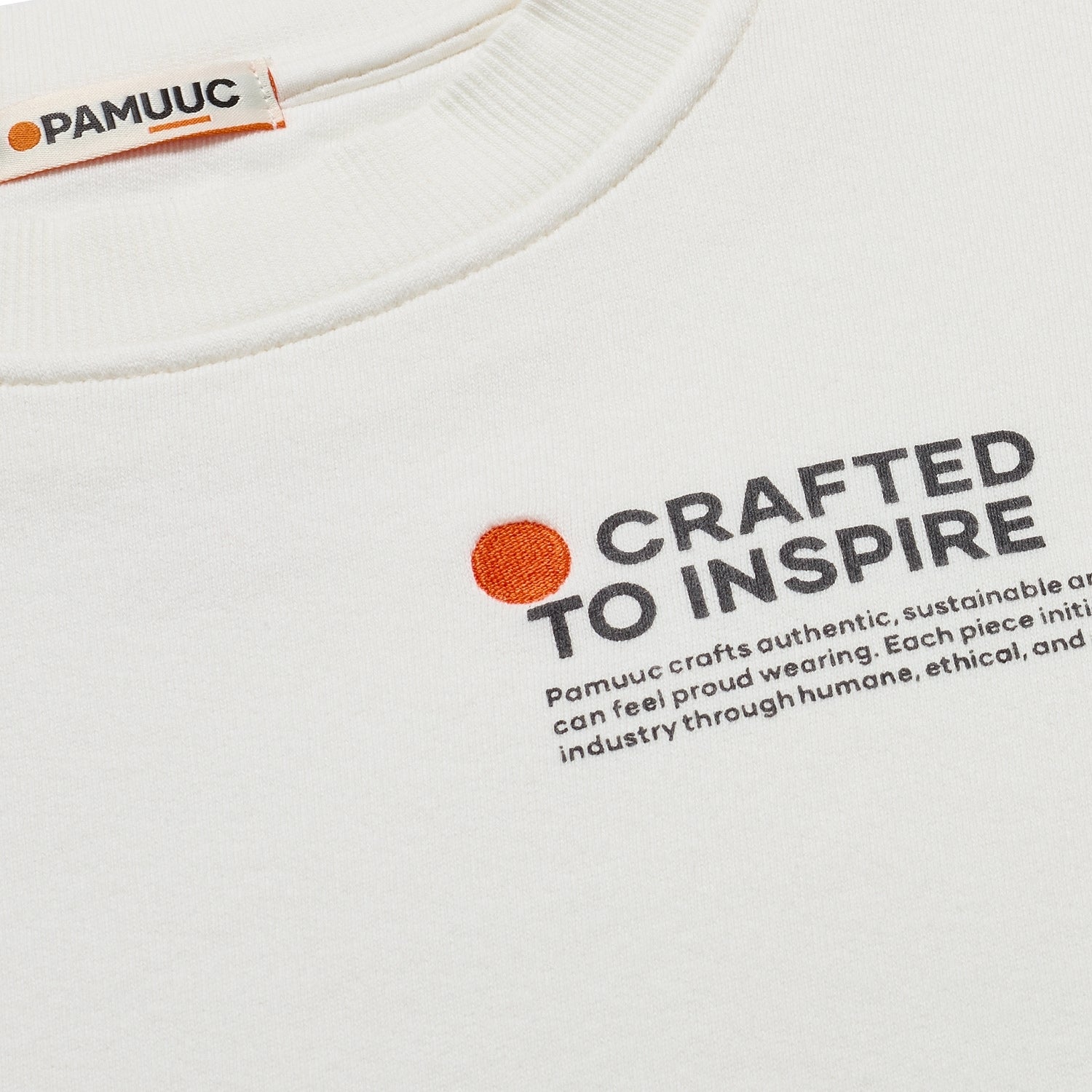 Close-up of "Crafted to Inspire" text on white crewneck