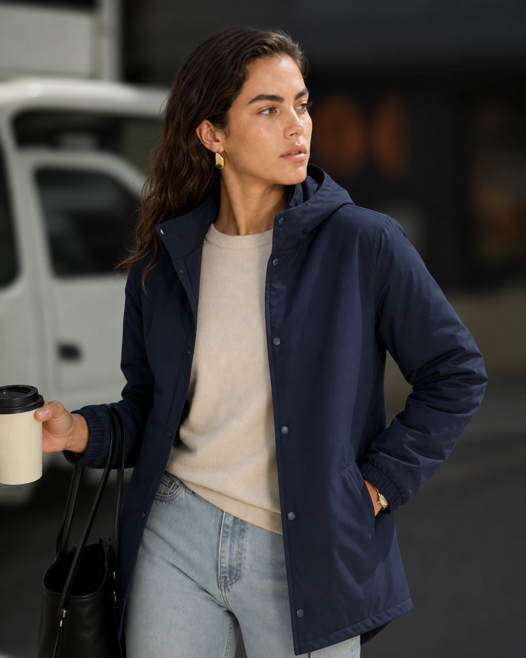 Frau mit Parka in Marineblau holding coffee cup auf street