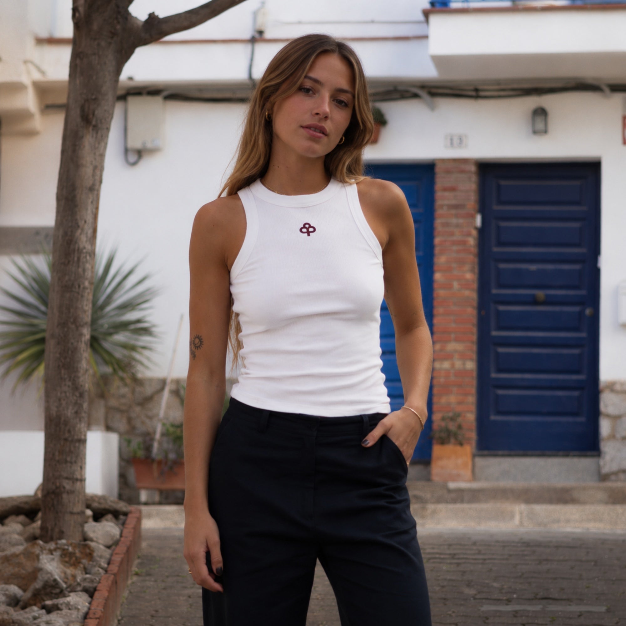 White cotton tank top, front view showing high round neckline, wide shoulder coverage and slim ribbed fit